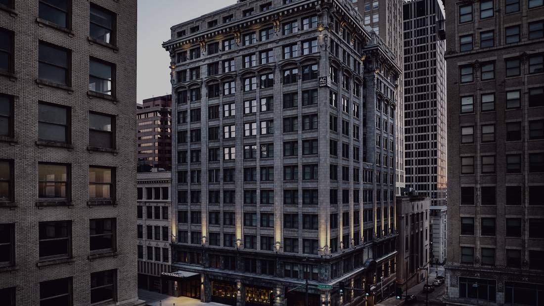 The AC Hotel Kansas City Downtown seen across the street at dusk.