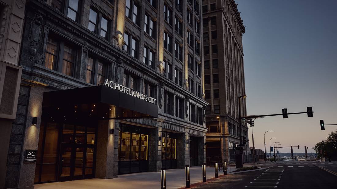 Street-level dusk view of the AC Hotel Kansas City Downtown entrance on Grand Boulevard.