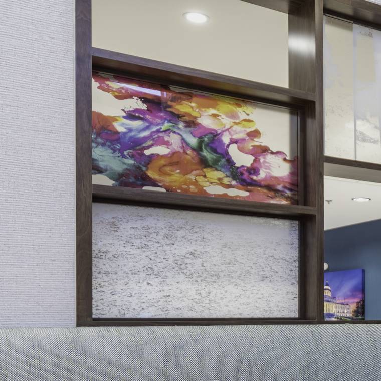 Framed abstract artwork set into a walnut shadow-box wall.