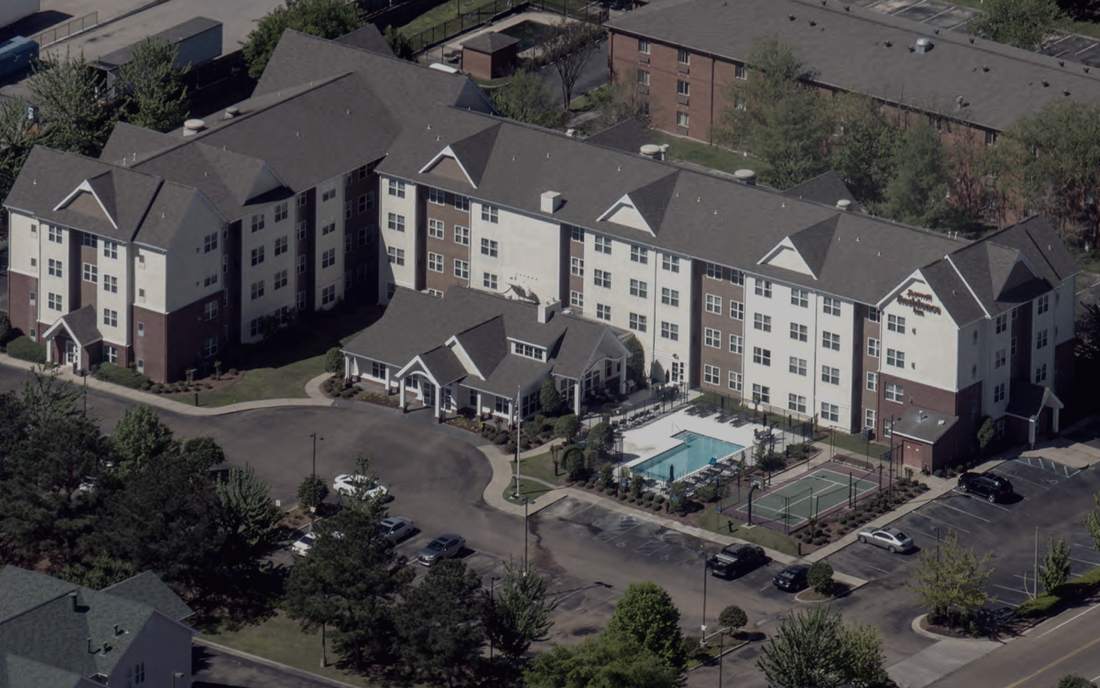Aerial view of the Residence Inn by Marriott in Ridgeland, Mississippi, showing the four-storey building, the pool courtyard and the sport court.